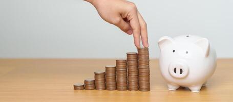 Money Saving for Future Plan, Retirement fund, Pension, Investment, Wealth, Salary and Financial concepts. hand step up coin with piggy bank on table, Money Counting and stack arrangement for Growth photo