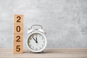 Happy New Year with vintage alarm clock and 2025 block. Christmas, New Start, Resolution, countdown, Goals, Plan, Action and Motivation Concept photo