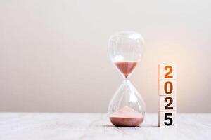 2025 text with hourglass on table. Resolution, time, plan, goal, motivation, reboot, countdown and New Year holiday concepts photo