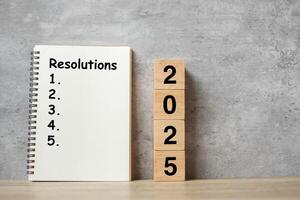 2025 Happy New Year with Resolution notebook and wooden number. countdown, Goals, Plan, Action and Mission Concept photo
