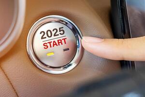 Finger press a car ignition button with 2025 START text inside automobile. New Year New You, forecast, resolution, motivation, change, goal, vision, innovation and planning concept photo