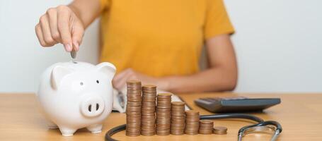 Money Saving, Health Insurance, Medical, Donation and Financial concepts. woman with coins stack and piggy bank and stethoscope, Money stack Counting arrangement for deposit and Healthcare cost photo