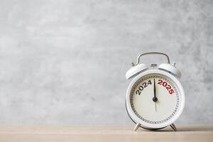 Happy New Year with vintage alarm clock and 2024 change to 2025 number. Merry Christmas, New Start, Resolution, countdown, Goals, Plan, Action and Mission Concept photo