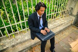 Man working on a laptop with a concerned expression photo