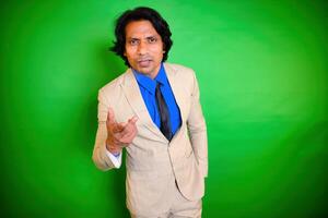 Man in beige suit pointing towards the camera photo