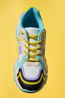 Stylish colorful shoe isolated on yellow background photo