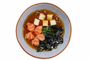 Closeup on appetizing ishikari miso soup with salmon in a black bowl, horizontal photo