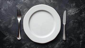 Minimalist table setting with white plate and silverware photo