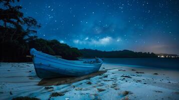 A blue boat rests on the sandy shore photo