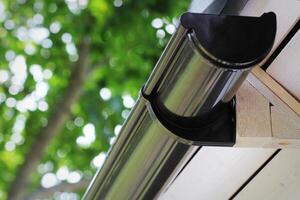 Rain Gutter Pipeline System Installation. Roofing Construction. Rain gutter system and roof protection from snow photo
