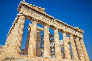 Ancient Parthenon Temple on top of the Acropolis Athens, Greece at sunny day with a blue sky. The landmark of Athens. Parthenon is the temple of for dedication to the goddess Athena. photo