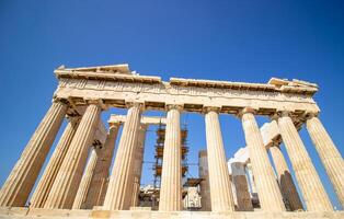 Ancient Parthenon Temple on top of the Acropolis Athens, Greece at sunny day with a blue sky. The landmark of Athens. Parthenon is the temple of for dedication to the goddess Athena. photo
