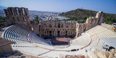 The ancient theatre of Dionysus on the slope of the Acropolis hill in Athens, Greece. View of the famous Dionysus Theatre on a sunny day with a beautiful sky. photo