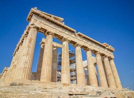 Ancient Parthenon Temple on top of the Acropolis Athens, Greece at sunny day with a blue sky. The landmark of Athens. Parthenon is the temple of for dedication to the goddess Athena. photo