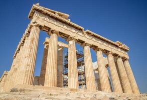 Ancient Parthenon Temple on top of the Acropolis Athens, Greece at sunny day with a blue sky. The landmark of Athens. Parthenon is the temple of for dedication to the goddess Athena. photo