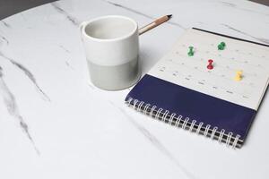 View of Yellow pushpin on calendar page schedule to make appointment and reminder about meeting or deadline photo