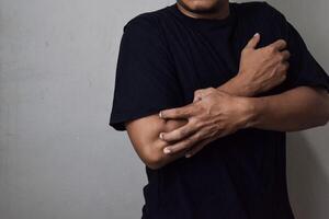 View of man scratching hand with allergy isolated on beige background photo