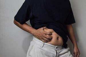 A man having stomachache on beige background photo