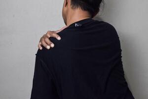 Man itching on shoulder. Medical and healthcare concept photo