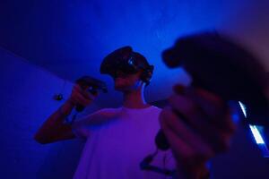 A player plays a game using a virtual reality helmet in a neon room. Close-up photo. photo