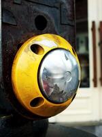 pedestrian safety button in yellow. The button is unperfect condition with a little rust, this are a sign of poorly maintained public facilities. photo