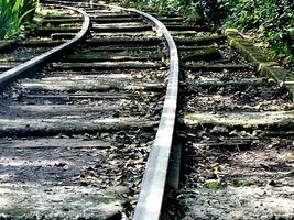 railway that leads into a forest. Old railway curve. Mass transportation concept background photo