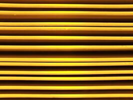 Abstract background image of vibrant color yellow metal sheets. Yellow metal tile fence background. Yellow zinc metal sheet texture. photo