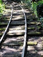 railway that leads into a forest. Old railway curve. Mass transportation concept background photo