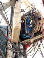 messy electric power cables installation. chaotic network of a tangled electrical wires. Unsightly electric wires on public area causing danger to health and safety. photo