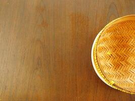 Bamboo tray on wooden texture background with copy space for text photo