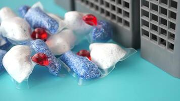 A stack of dishwasher tablets and a bottle of detergent on a blue background video