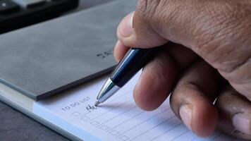 To do list in notebook with office suppliers on desk video
