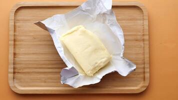 slice of a butter on a paper on table . video