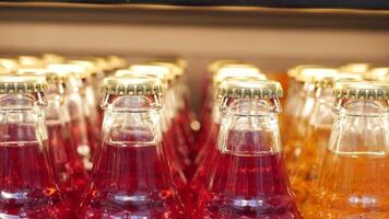 Vintage beverage bottles with colorful caps on bar shelf create a nostalgic retro drinks display video