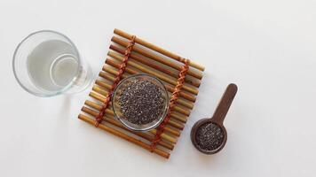 top view of chia seed in a container and glass of water on table video