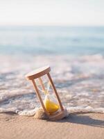 Hourglass on the beach in the sunset time. The concept about countdown to Summer, Travel, Vacation and Relaxation. photo