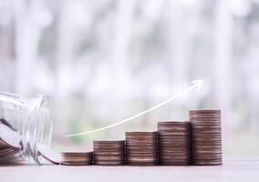Stack of coins with arrow rising up. The concept of saving money, Financial, Investment and Business growing up. photo