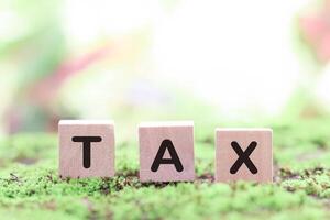 Wooden blocks with the word TAX. The concept of prepare to pay tax. photo