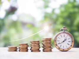 Vintage watch and stack of coins with arrow rising up. The concept of saving money for manage time to success business. photo