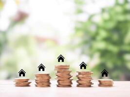 Miniature house icons and stack of coins. The concept of saving money for house, manage time to Property investment, House mortgage, Real estate. photo