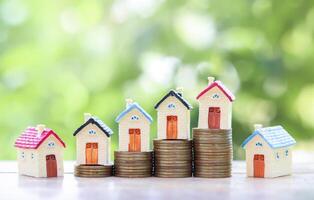 Miniature house on stack of coins. The concept of saving money for house, Property investment, House mortgage, Real estate photo