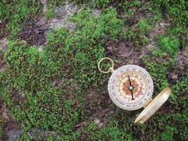 Compass with green moss background. The concept of world tourism day, Searching the right directions and Travel photo
