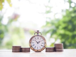 Vintage watch and stack of coins. The concept of saving money for manage time to success business. photo