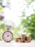 Vintage watch and stack of coins. The concept of saving money for manage time to success business. photo