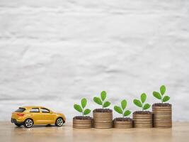 Toy car and plants growing up on stack of coins. The concept of business growth, saving money and manage to success transport business photo
