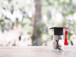 Glass bottle with graduation hat. The concept of saving money for education, student loan, scholarship, tuition fees in the future photo
