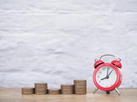 Yellow alarm clock and stack of coins. The concept of saving money, manage time to success Financial, Investment and Business growing up. photo