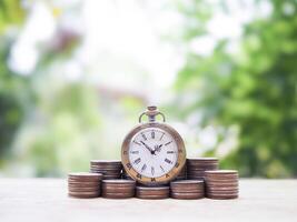 Vintage watch on stack of coins. The concept of saving money for manage time to success business. photo