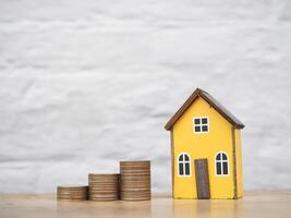 Miniature house and stack of coins. The concept of saving money for house, Property investment, House mortgage, Real estate photo