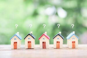 Miniature house with question mark icons.The concept of choosing suitable house for planning living in the future. Real estate photo